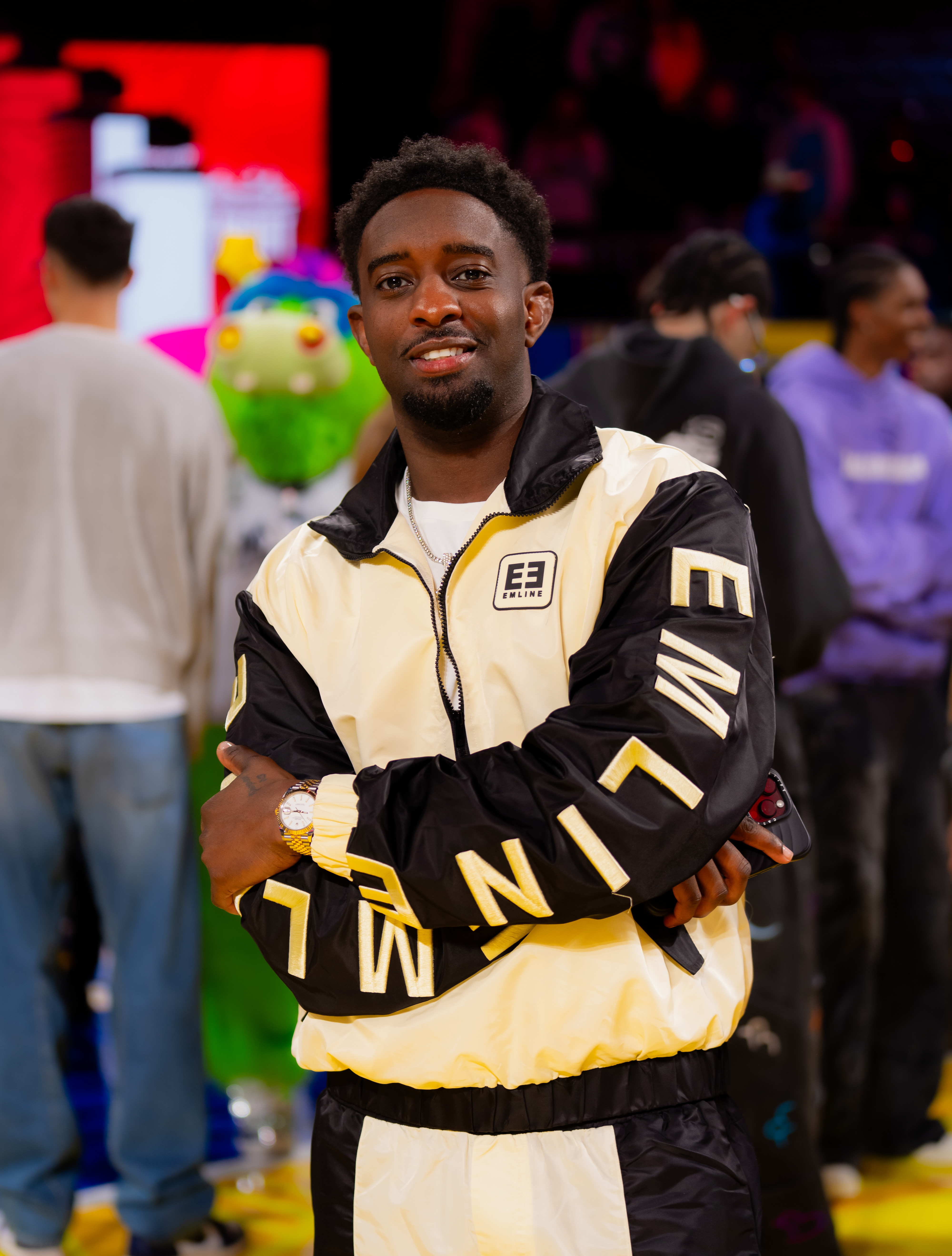 Young man in branded tracksuit on the court floor at the 2025 NBA All-Star Weekend